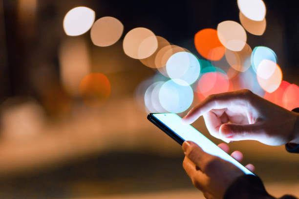 istock Using a smartphone in the city at night 1475001972