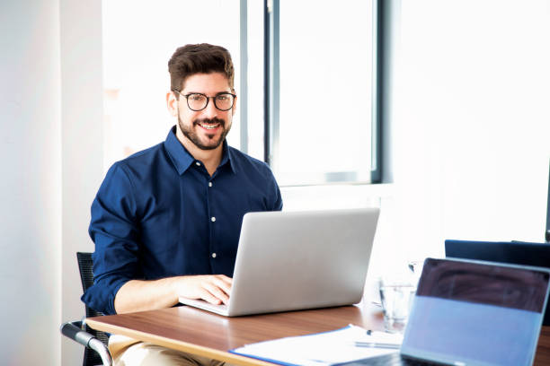 istock Caucasian businessman sitting in a modern office and using laptop for work 1475003267