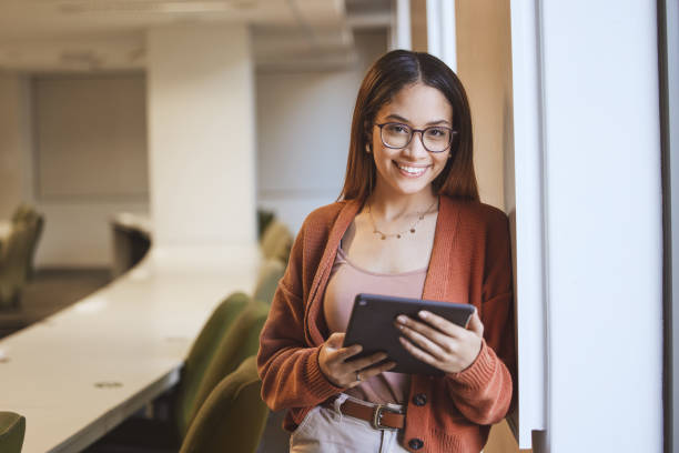 istock Face, student and woman with tablet in classroom for knowledge research. Portrait, university and happy female from Brazil holding touchscreen for learning, studying and education in lecture room. 1475003693