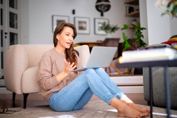 istock Brunette haired attractive woman using laptop an having video call at home 1475004438