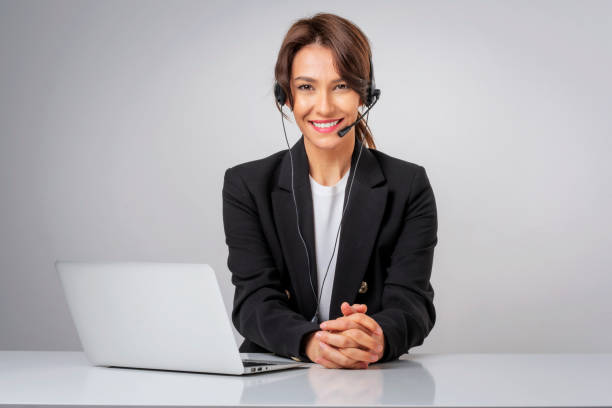 Studio portrait of a call center assistant businesswoman sitting against isolated background stock photo