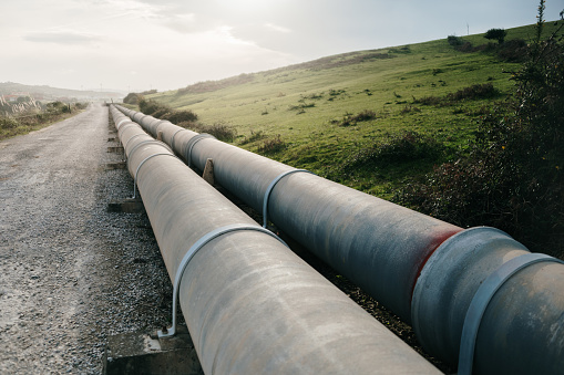 Two large pipelines on the side of a road