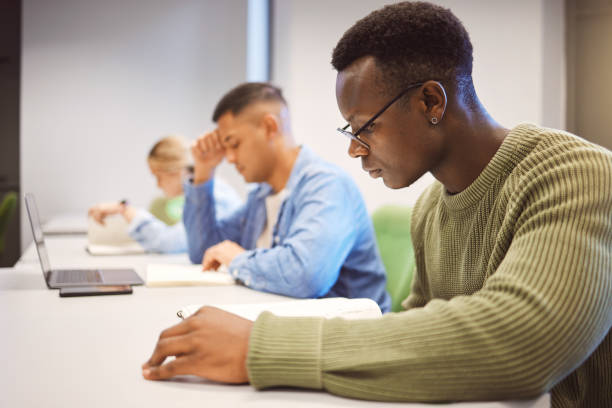 Black man, students and studying for education, knowledge and focus for exams, campus and intelligent. African American male, student and young people on university, concentration and research notes Black man, students and studying for education, knowledge and focus for exams, campus and intelligent. African American male, student and young people on university, concentration and research notes community college stock pictures, royalty-free photos & images