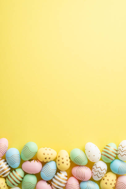 istock Easter concept. Top view vertical photo of colorful easter eggs on isolated yellow background with empty space 1475006280