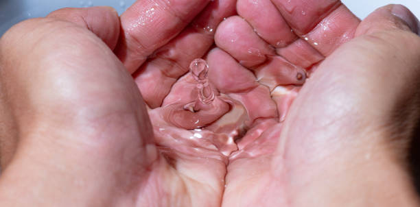 istock Water droplets bouncing in the hand 1475008962