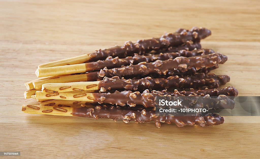 crispy sweet straws filled chocolate crispy sweet straws filled chocolate with crushed nuts against the wooden table Abundance Stock Photo
