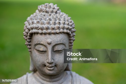 istock buddha statue face in the garden 1475015892