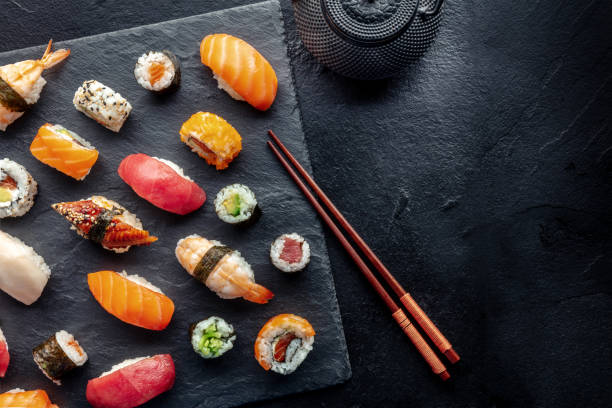 istock Sushi overhead flat lay shot with chopsticks, tea, and copy space 1475018912