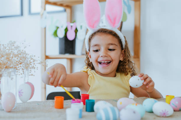 istock Child girl painting easter eggs 1475019631