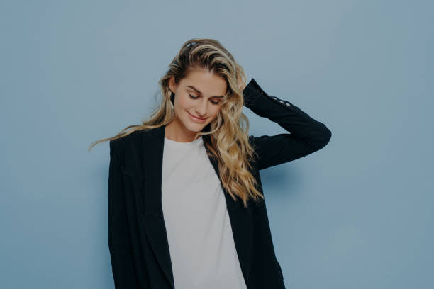 istock Beautiful smiling female with blonde dyed hair feeling happy while posing in studio 1475019829