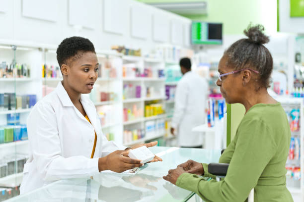 istock Female pharmacist talking with senior customer 1475020727