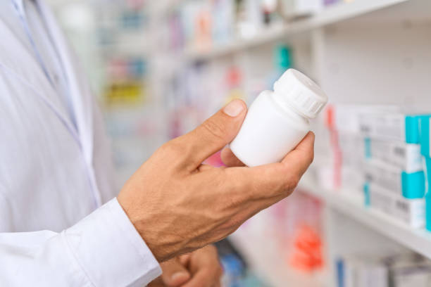 istock Male pharmacist holding pill bottle 1475020890