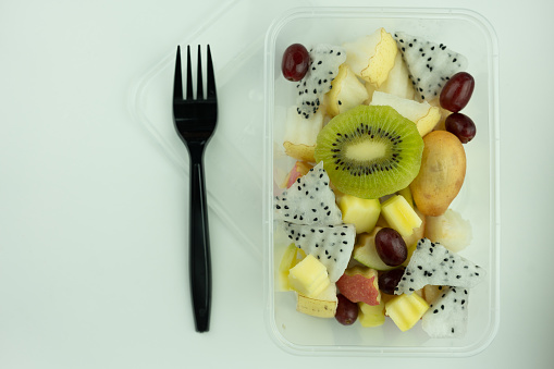 Mix of tropical fruit served in a plastic box. Freshly fruit salad. Food delivery. Healthy food