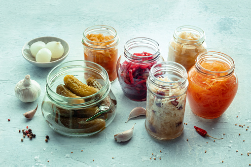 Fermented food. Vegetable preserves. Sauerkraut, pickled cucumbers, kimchi etc in glass jars, with pepper and garlic. Healthy probiotic diet