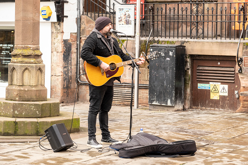 Shrewsbury Shropshire united kingdom 20, October 2022 A lone busker plays guitar and sings to the sunday shoppers