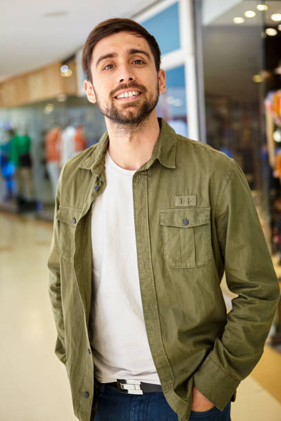 istock Young adult man looking at the camera while standing with hands in pocket 1475032330