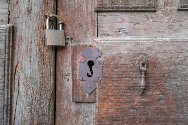 istock Old rusty iron lock and wrought iron hasp on an old wooden door 1475033281