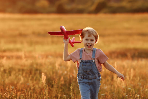 istock Child launches a toy plane in the field 1475036901