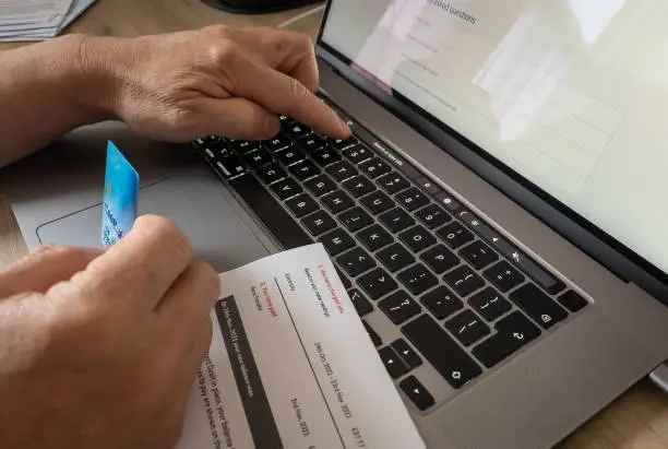 A person paying a energy bill using a card online.