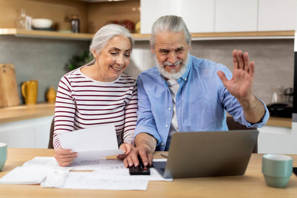 istock Senior Spouses Making Video Call With Accountant While using Laptop In Kitchen 1475041165