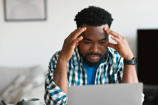 istock Thoughtful African American Man Using Laptop Working Online Sitting Indoors 1475041276