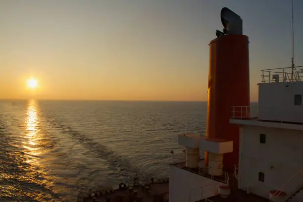 Photo of View of the stern of a merchant ship at sea in the evening