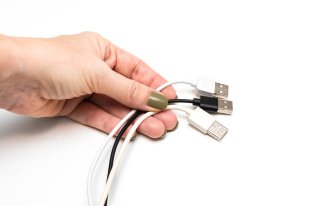 female hand holding wires on a white background. hand holding computer wires