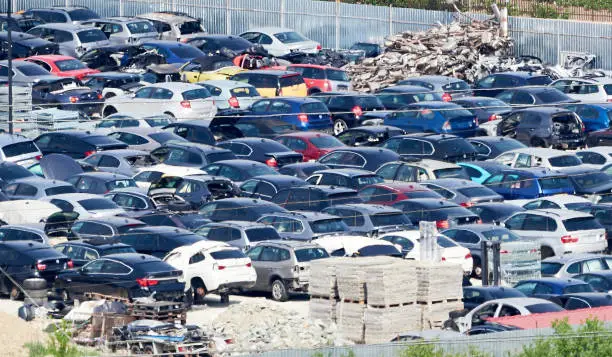 Photo of Car dump. A bunch of old broken cars in the field.