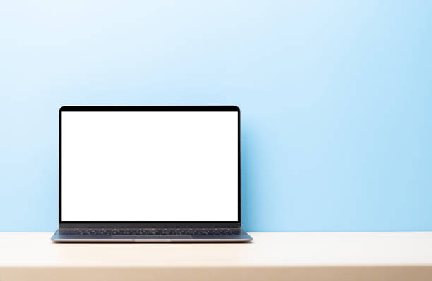 Laptop with blank screen on wooden table