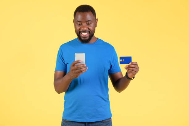 istock Black Male Using Phone And Credit Card Making Payment, Studio 1475049027