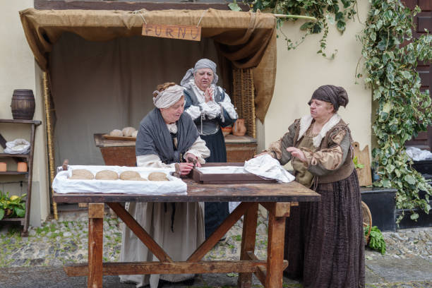 Taggia, Italy - February 26, 2023: Participants of historical reenactment in the old town of Taggia, in Liguria region of Italy. The actors acting out episodes of daily life in settings that evoke moments of life lived fully the seventeenth century. The episodes depicted are inspired by true events, drawn from documents preserved in the Historical Archives