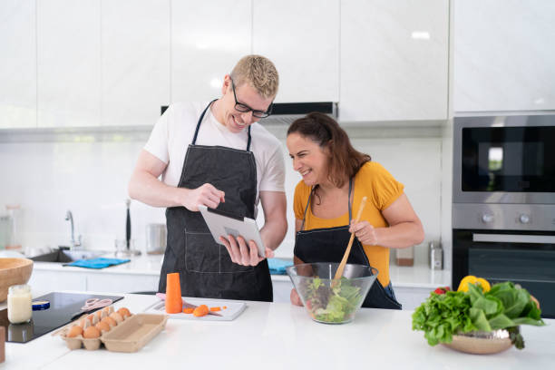 istock Happy couple cooking together in their kitchen 1475051225