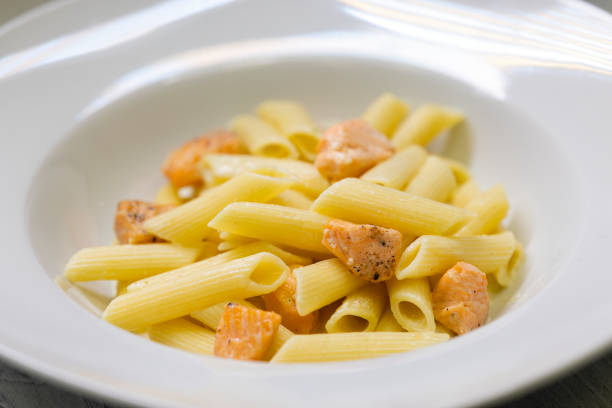Pasta in lemon sauce with salmon fillets in herb coating and corn salad as a side dish.