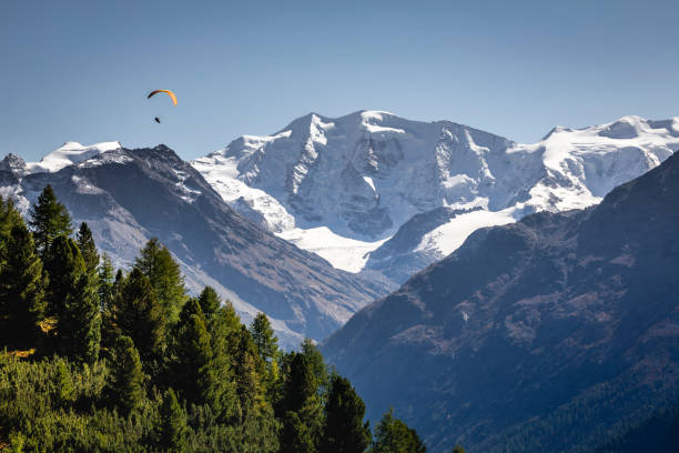 parapente sobre a paisagem alpina em muottas muragl, vale da engadine, graubunden, alpes suíços - paragliding engadine mountain switzerland - fotografias e filmes do acervo