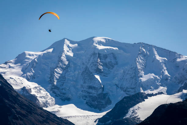 parapente sobre a paisagem alpina em muottas muragl, vale da engadine, graubunden, alpes suíços - paragliding engadine mountain switzerland - fotografias e filmes do acervo