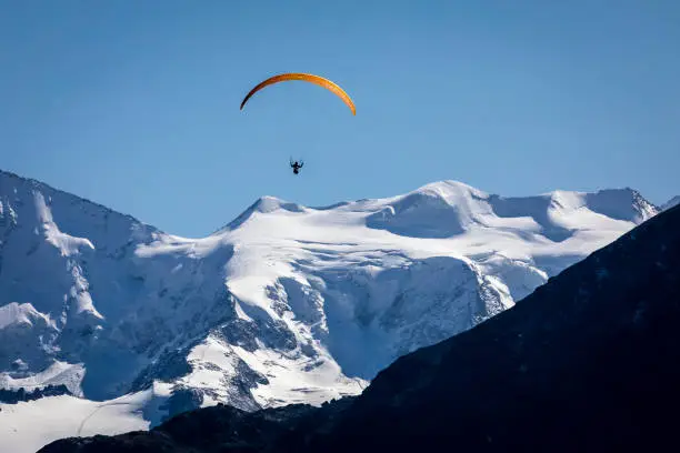 Paragliding over Alpine Landscape in Muottas Muragl, Engadine Valley, Graubunden, Swiss Alps above St Moritz, Switzerland
