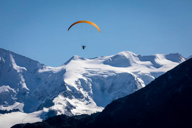 парапланеризм над альпийским ландшафтом в муоттас-мурагль, долина энгадин, граубюнден, швейцарские альпы - berninapass стоковые фото и изображения