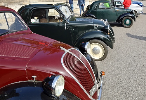 Percoto, Italy. March 19, 2023. Three Fiat 500 Topolino, vintage car from the Thirties, waiting to participate to a collector's car auto gathering later.