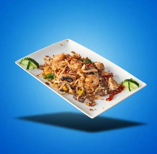 Photo of Floating Pad Thai on White Plate on blue gradient