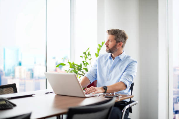 istock Confident professional man sitting at office desk and usin laptop for work 1475052884