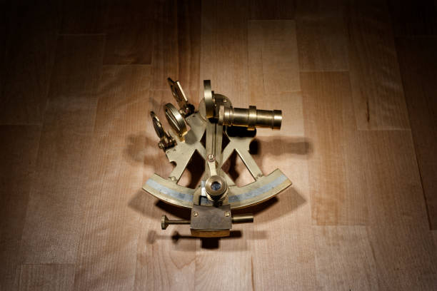 old sextant, spyglass, circle and compass lying on wooden table