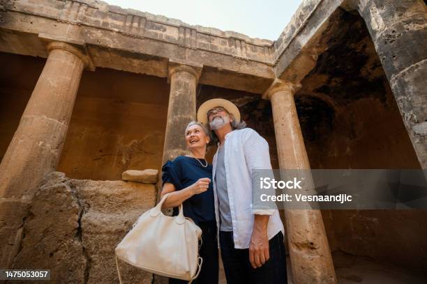 Mature Couple Visiting Cyprus Tombs Of The Kings Necropolis On Paphos Stock Photo - Download Image Now