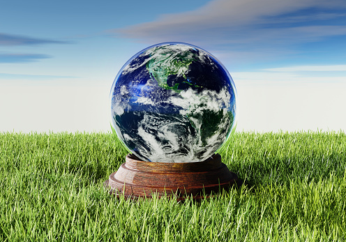 Earth in glass globe on grass with blue sky background. Environment conservation and Nature concept. 3D illustration rendering