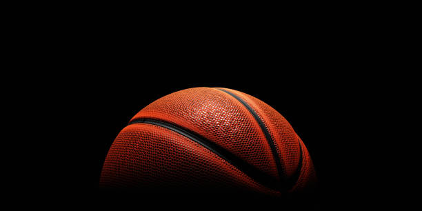 Basketball with spotlight and fade-out shadow in the dark background. Copy space. Sport and game concept. 3D illustration rendering stock photo