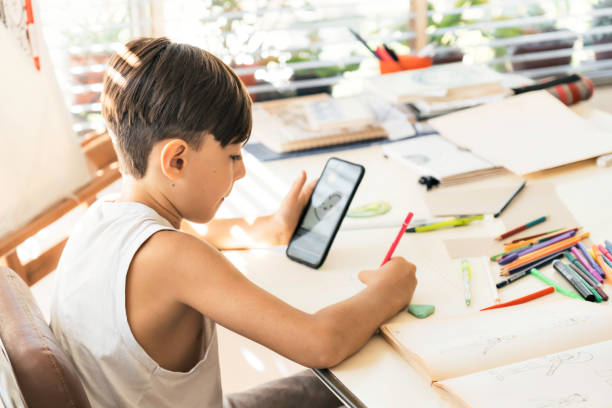 istock A boy is learning to draw with her smart phone. 1475055162