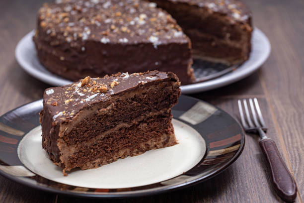 Plate with slice of tasty homemade chocolate cake on table stock photo