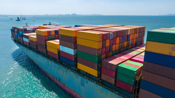 istock Side Ship view of Cargo Container Ship with Tug boat carrying container and running very fast for export cargo from container yard port to custom ,Contrail line in the ocean 1475057328