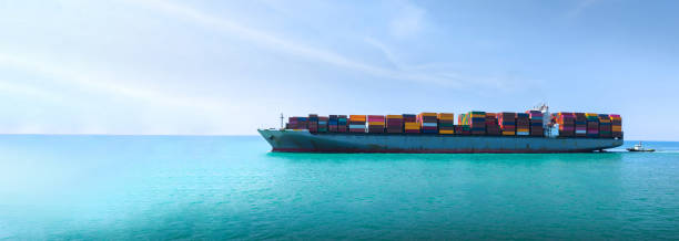istock Side Ship view of Cargo Container Ship with Tug boat carrying container and running very fast for export cargo from container yard port to custom ,Contrail line in the ocean 1475057363