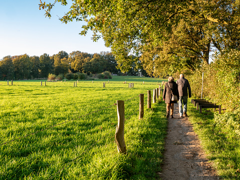 Older couple walking on footpath through nature near town of Ootmarsum, Overijssel, Netherlands