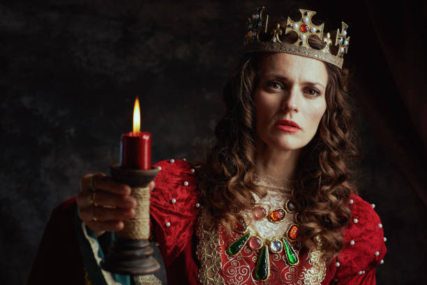 istock medieval queen in red dress with candle and crown 1475063243